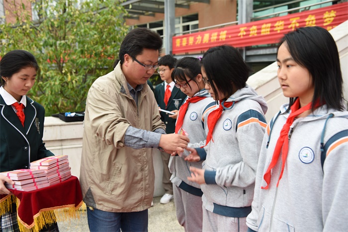 图7清水亭副校长钟文楼老师为学生代表发离队纪念卡.JPG