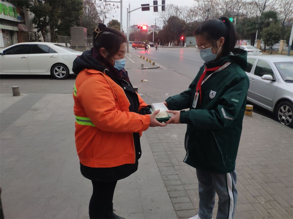 陈梓欣同学在向环卫工人赠送新年第一份早餐.jpg