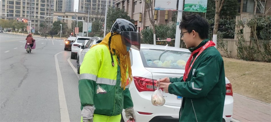 李宇轩同学在向环卫工人赠送新年第一份早餐.jpg