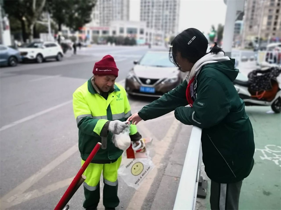 向晨曦同学在向环卫工人赠送新年第一份早餐.jpg