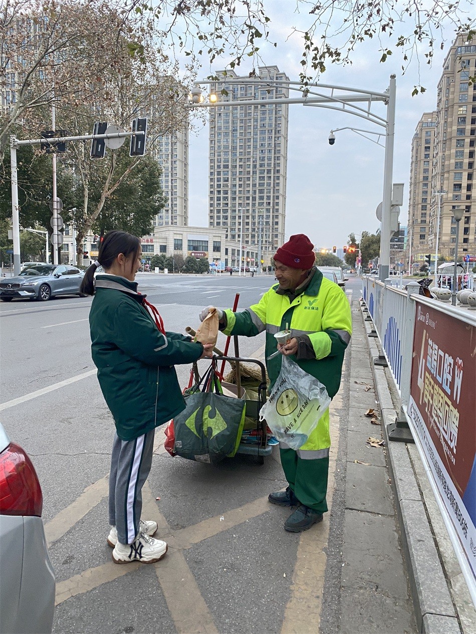 尹馨同学在向环卫工人赠送新年第一份早餐.jpg